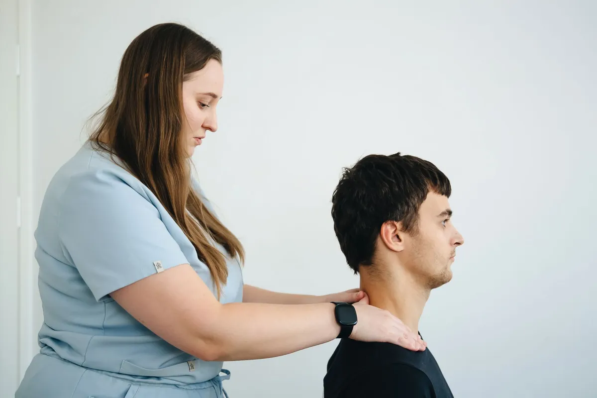 A physiotherapist working on a patient's neck and shoulder